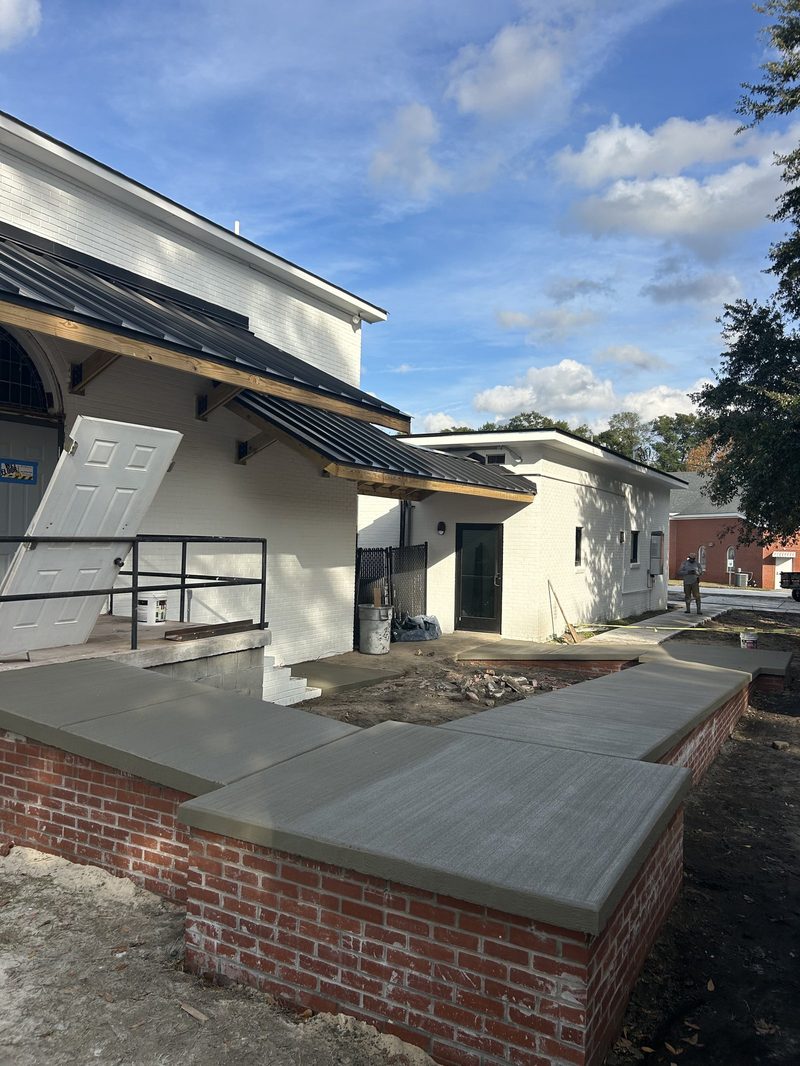 New concrete sidewalks with brick wall at commercial renovation in Spartanburg SC